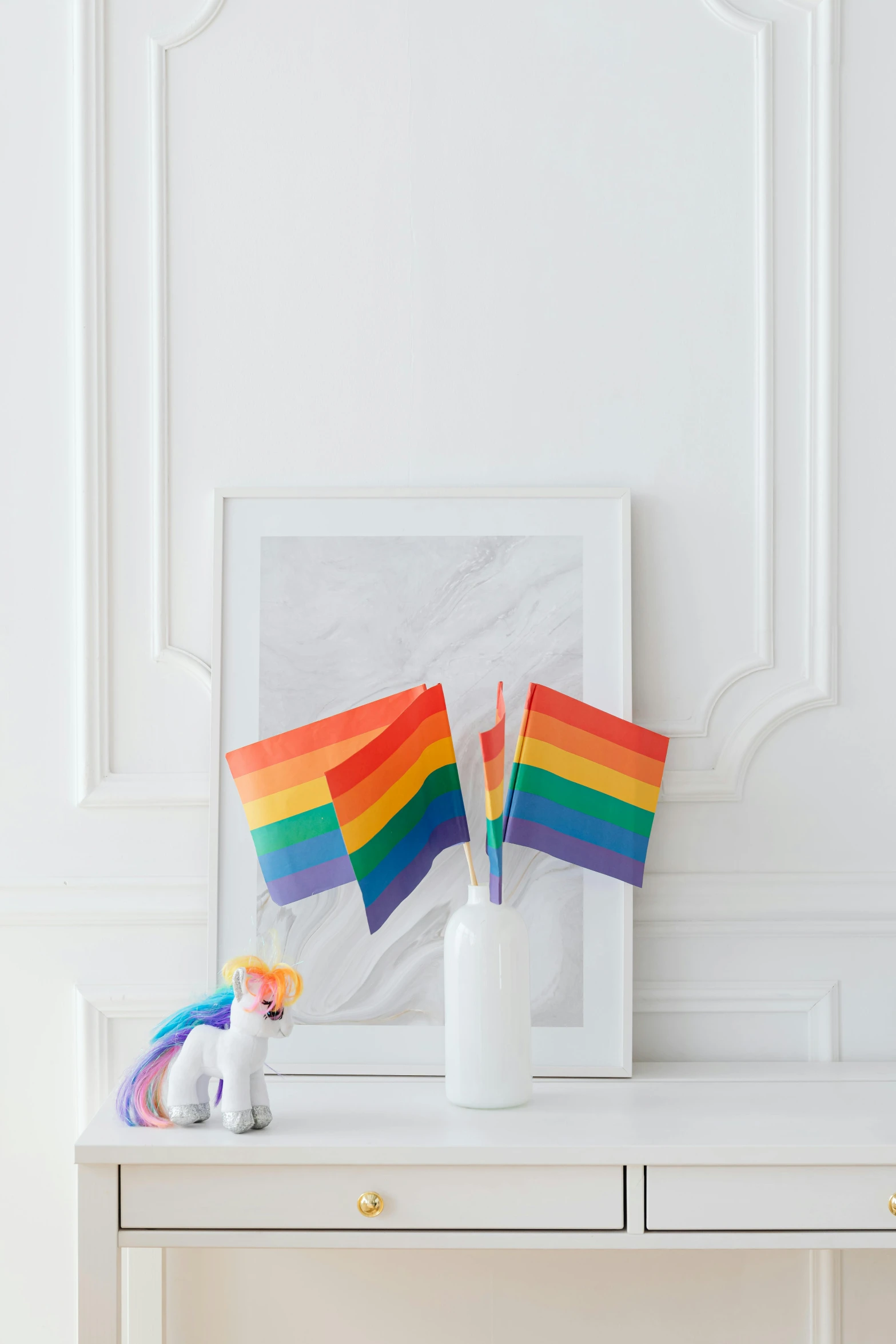 a rainbow flag sitting on top of a white table, art toys on a pedestal, white unicorn, gang flags, clean image