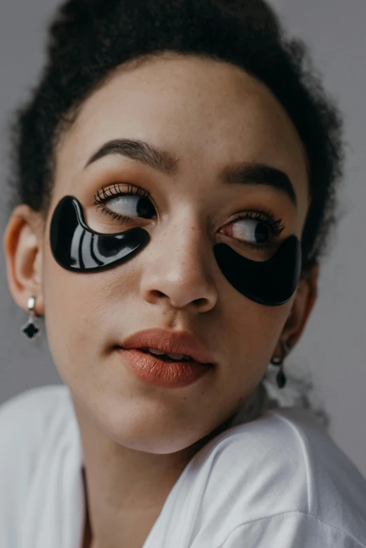a woman with eye patches on her face, by Julia Pishtar, trending on pexels, made of smooth black goo, wavy, glossy photo, black teenage girl