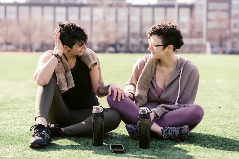 a couple of women sitting on top of a lush green field, by Nina Hamnett, pexels contest winner, wearing fitness gear, drink milkshakes together, in a city park, avatar image