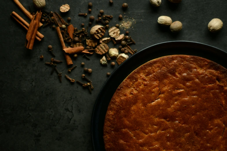 a cake sitting on top of a pan on top of a table, by Julia Pishtar, trending on pexels, renaissance, spices, bottom angle, high quality product image”, square