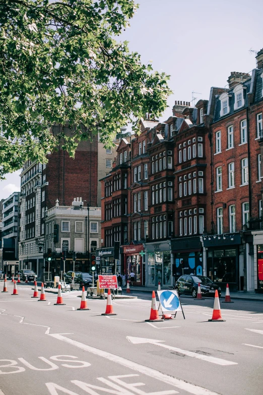 a street filled with lots of traffic next to tall buildings, arts and crafts movement, road street signs, england, 🚿🗝📝