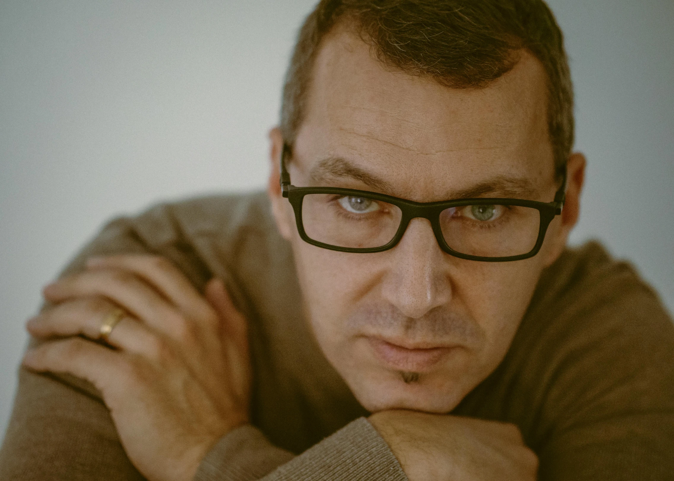 a close up of a person wearing glasses, an album cover, pawel rebisz, serious look, grayish, man in his 40s