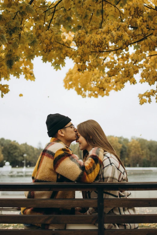 a man and a woman are sitting on a bench, pexels contest winner, kissing together, in the autumn, espoo, 1 2 9 7