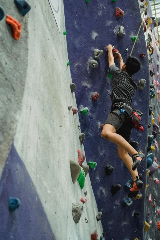 a man is climbing on a rock wall, pexels contest winner, softplay, asian male, man riding a giant mouse, hanging veins