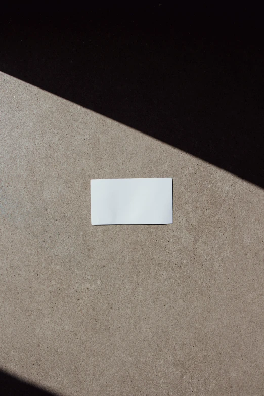 a piece of paper sitting on top of a table, by Daniel Seghers, unsplash, conceptual art, product label, high view, long shot from back, white metallic