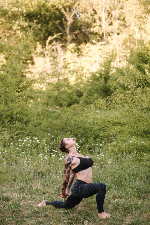 a woman standing in a field with a frisbee, a portrait, by Jessie Algie, unsplash, yoga pose, tattooed, in the hillside, kneeling