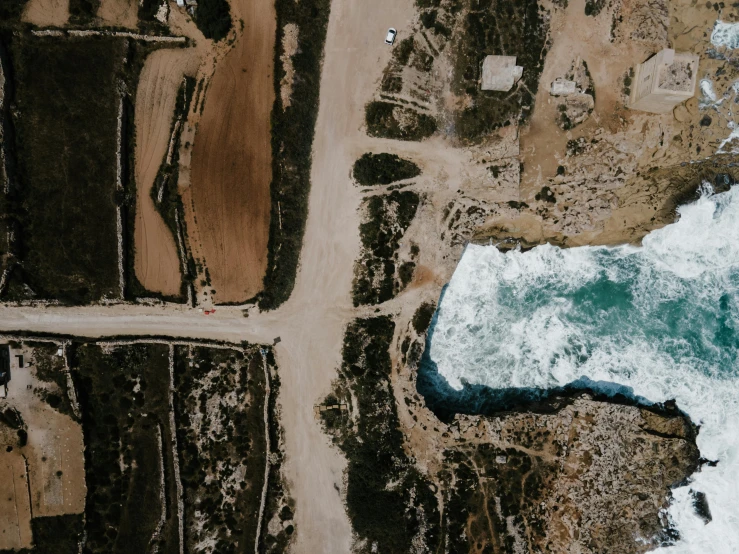 an aerial view of a large body of water, an album cover, by Lee Loughridge, pexels contest winner, land art, cyprus, thumbnail, rock quarry location, crashing waves and sea foam