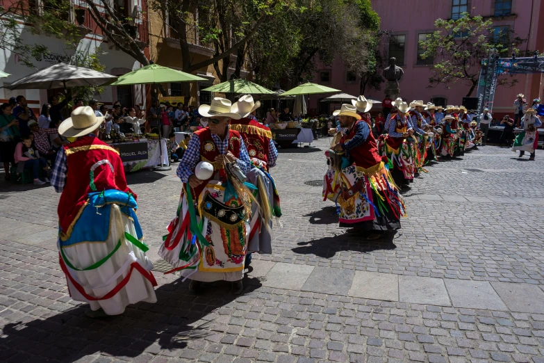 a group of people walking down a street holding umbrellas, pexels contest winner, quito school, robed figures sat around a table, chilaquiles, dance, avatar image