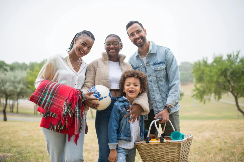 a family poses for a picture in a park, pexels, figuration libre, holding a football, picnic, avatar image, dark-skinned