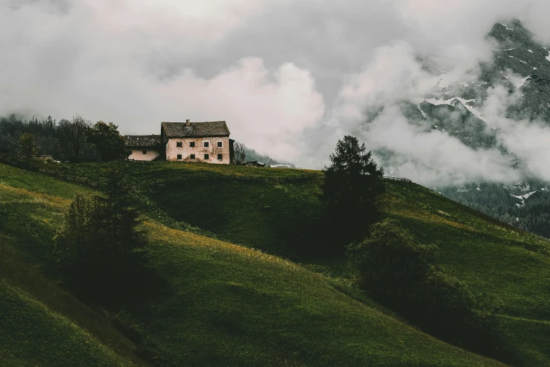 a house sitting on top of a lush green hillside, by Karl Buesgen, pexels contest winner, overcast gray skies, sound of music, profile image, cozy place