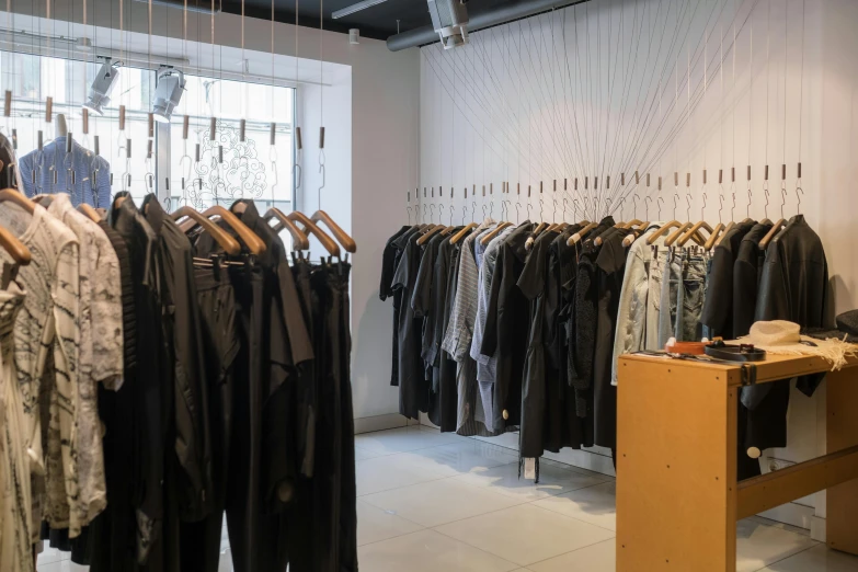 a room filled with lots of clothes on hangers, by Nina Hamnett, unsplash, gutai group, shop front, black leather garment, ignant, profile image