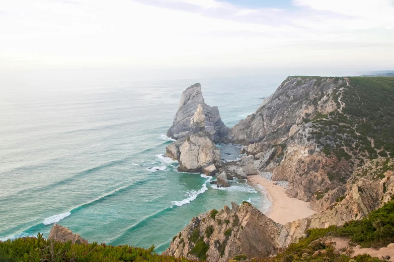 a man standing on top of a cliff next to the ocean, a photo, pexels contest winner, process art, portugal, square, “ aerial view of a mountain, hziulquoigmnzhah