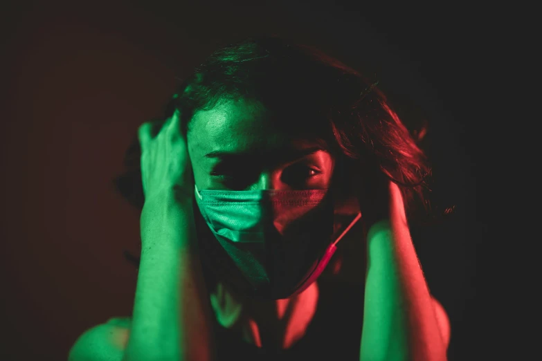 a woman wearing a face mask in the dark, a picture, green and red tones, struggling, avatar image, green and purple studio lighting