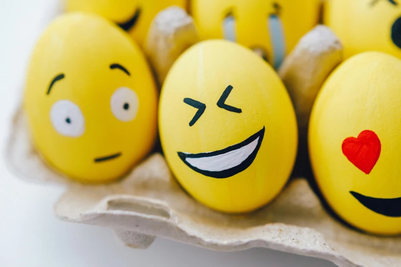 a carton of eggs with smiley faces painted on them, a cartoon, by Joe Bowler, trending on pexels, happening, yellow uneven teeth, celebration, smiling spartan, a still of a happy