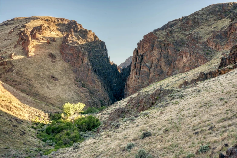 a person riding a horse through a canyon, near the black cauldron, large scale photo, oregon trail, landscape photo