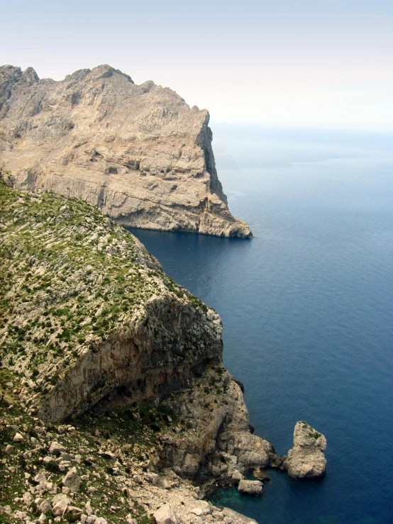 a large body of water next to a rocky cliff, inspired by Fede Galizia, pexels contest winner, les nabis, 2 5 6 x 2 5 6 pixels, “ aerial view of a mountain, coastal, balaskas