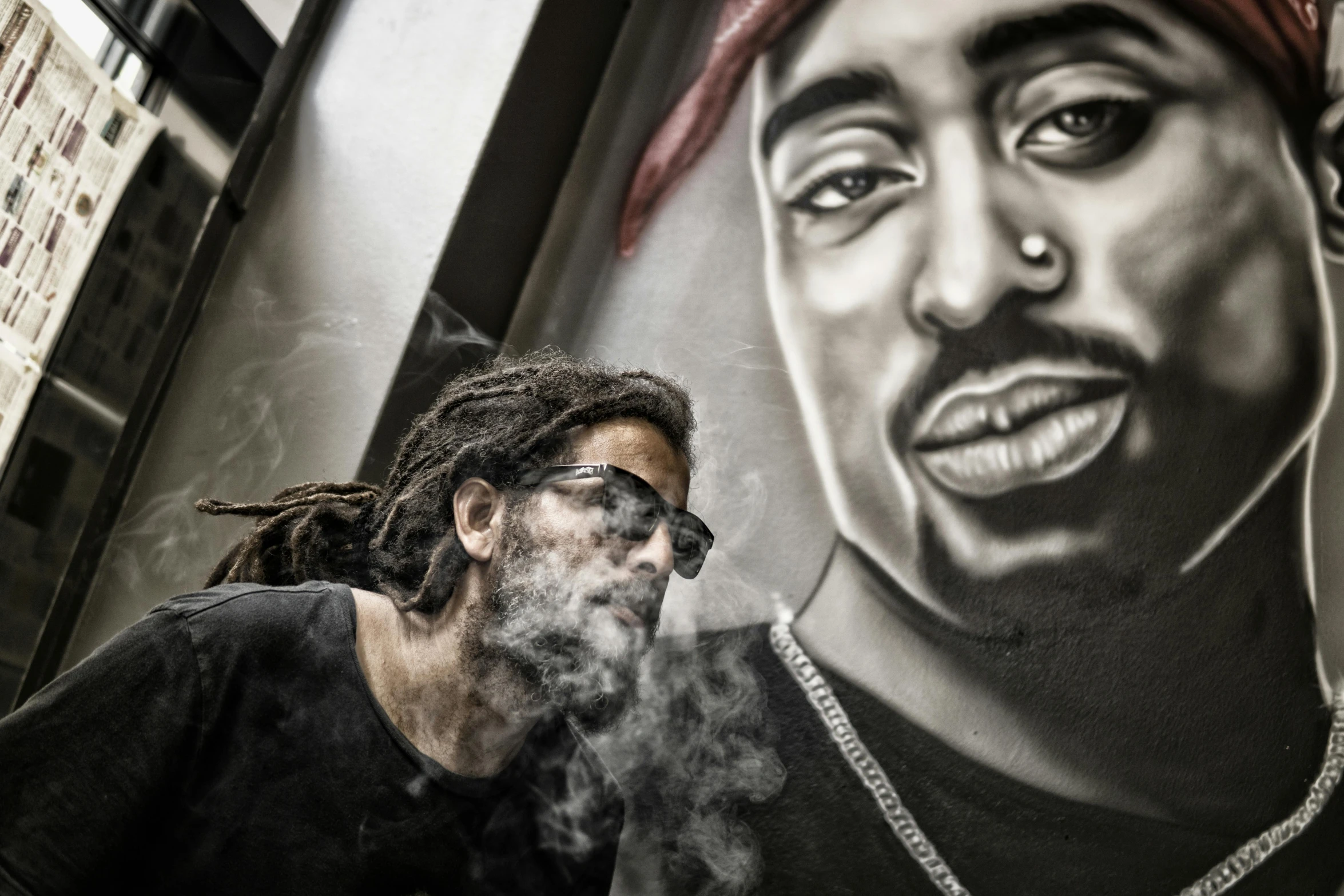 a man smoking a cigarette in front of a mural, an airbrush painting, pexels contest winner, tupac, gritty image, selfie, the dude