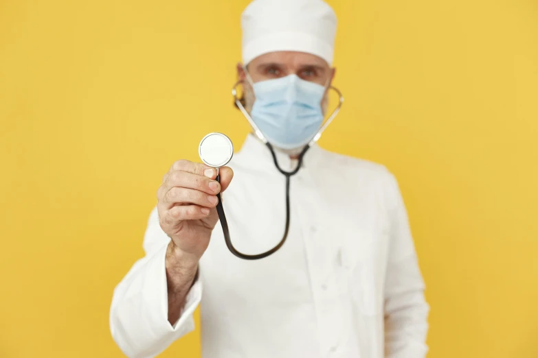a doctor with a stethoscope in his hand, by Adam Marczyński, pexels, hyperrealism, on a yellow canva, wearing mask, white uniform, instagram post