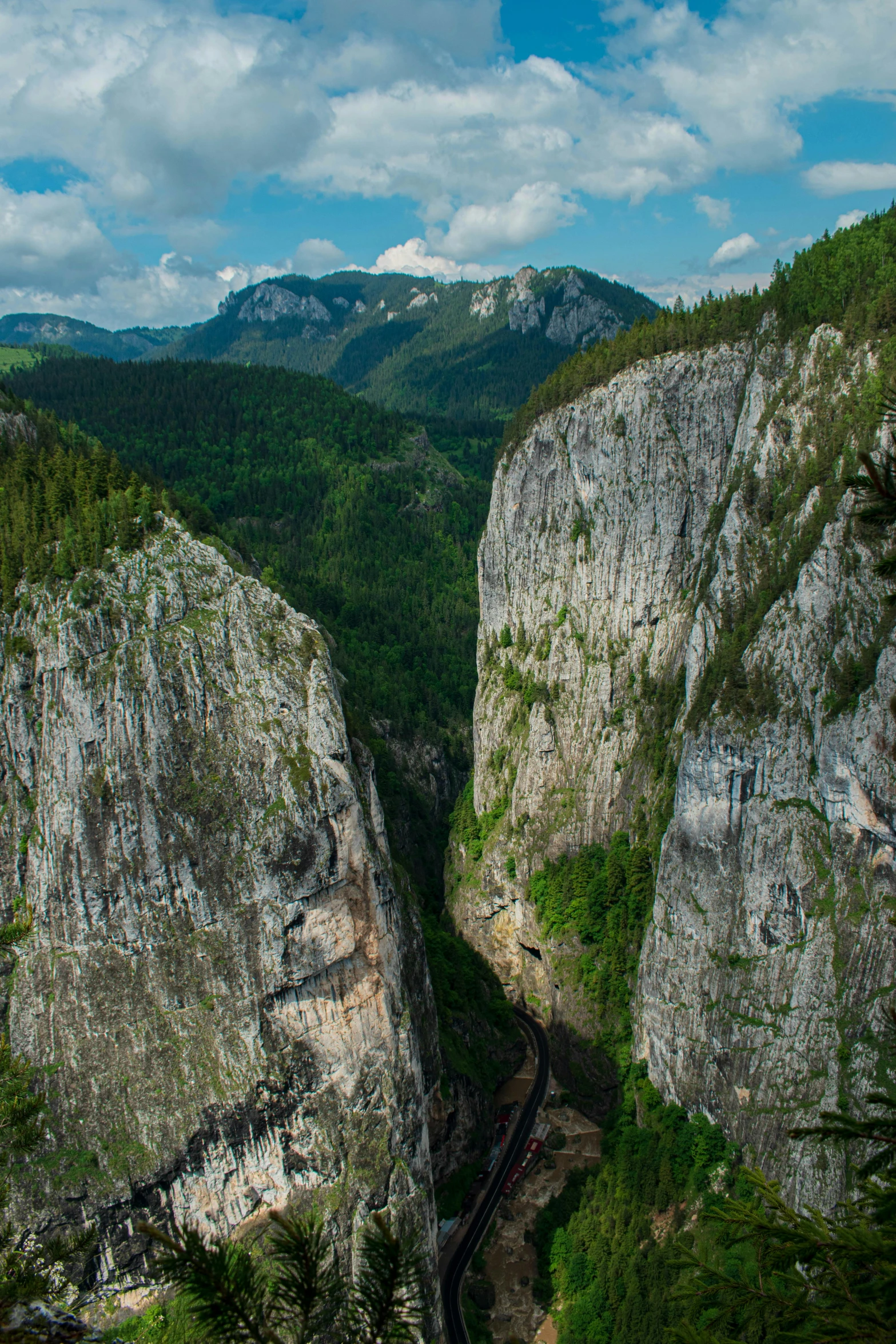 a train traveling through a lush green valley, a picture, by Franz Hegi, les nabis, huge chasm, slovenian, ultrawide image, tall big rocks