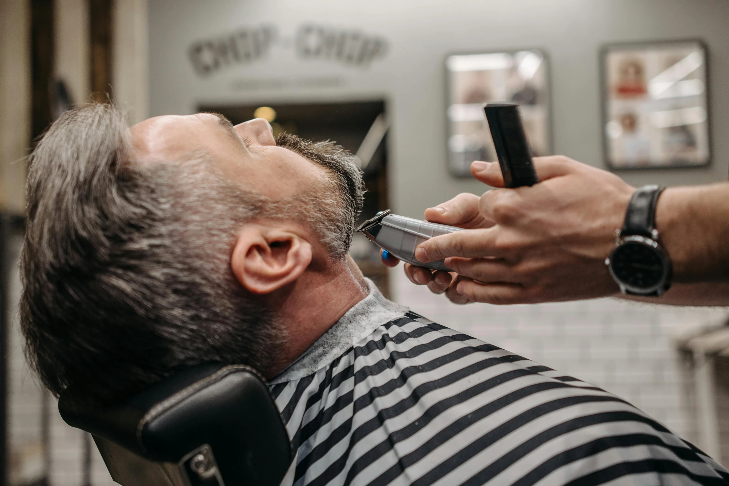 a man getting his hair cut at a barber shop, pexels contest winner, small dark grey beard, thumbnail, square masculine jaw, lachlan bailey