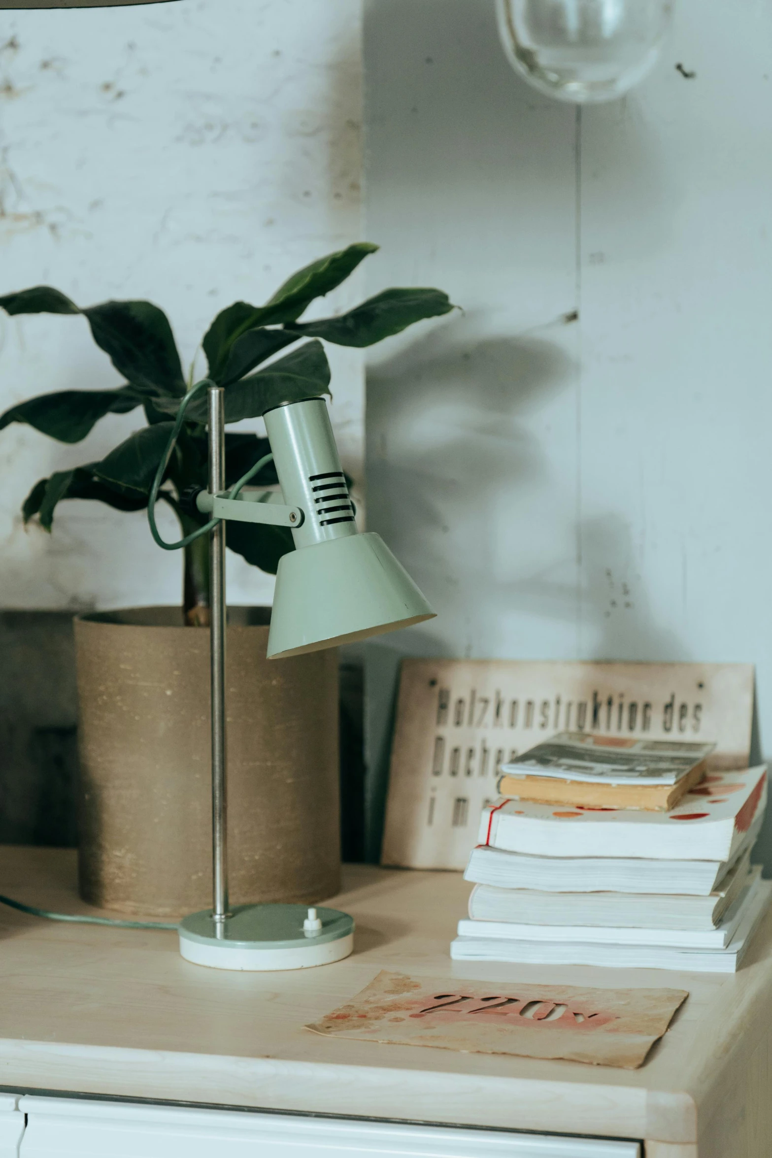 a lamp sitting on top of a table next to a pile of books, inspired by Elsa Bleda, unsplash contest winner, green plant, catalog photo, detailed product image, light green