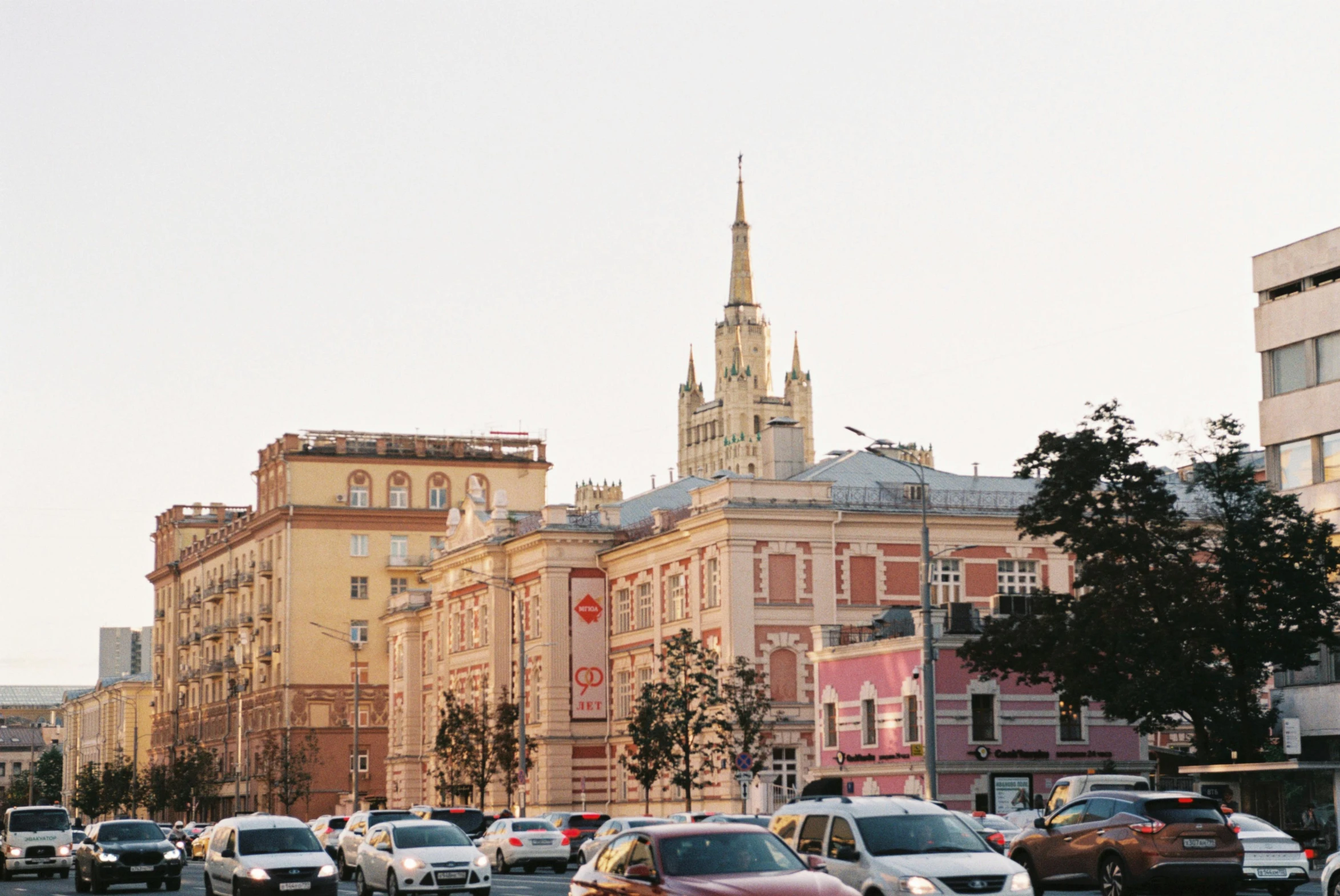 a street filled with lots of traffic next to tall buildings, inspired by Illarion Pryanishnikov, unsplash, socialist realism, square, kremlin, pink, kodak portra