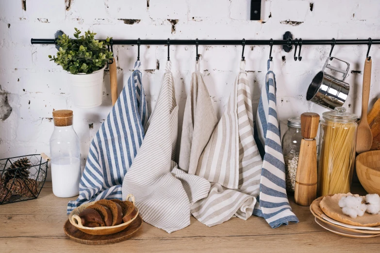 a bunch of towels sitting on top of a wooden table, inspired by Richmond Barthé, unsplash, baroque, on kitchen table, blue and white colour scheme, striped, various posed