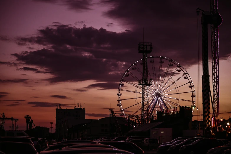 a ferris wheel sitting in the middle of a parking lot, by Dan Frazier, pexels contest winner, romanticism, purple sky, humid evening, surrounding the city, ariana grande photography