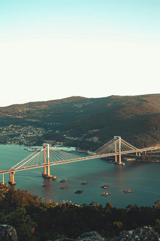 a large bridge over a large body of water, a tilt shift photo, pexels contest winner, hills and ocean, ultrawide cinematic, harbor, instagram post