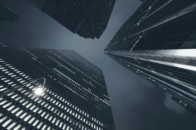 a black and white photo of skyscrapers in a city, pexels contest winner, digital art, 8 k. volumetric lighting. dark, low-angle, night time footage, beeple global illumination