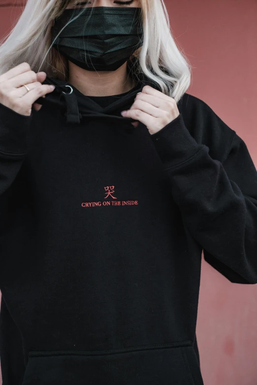 a woman wearing a black hoodie and a face mask, an album cover, inspired by Yu Zhiding, featured on reddit, cynical realism, embroidered shirt, detail shot, red on black, chillhop