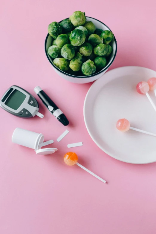 a white plate topped with lollipops next to a bowl of sprouts, by Julia Pishtar, unsplash, dau-al-set, syringes, hp mp stamina bars, pink, scales