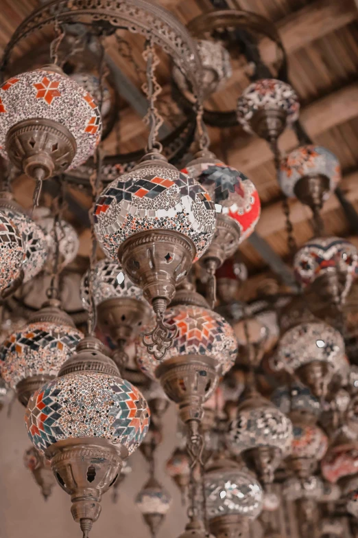 a bunch of lamps hanging from the ceiling, trending on pexels, arabesque, finely painted, mosaic, demur, trinkets