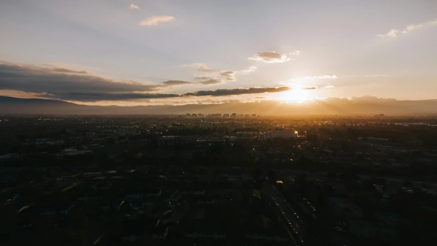 a view of the sun setting over a city, a picture, by Ryan Pancoast, unsplash contest winner, helicopter view, southern california, low quality photo, midday sunlight