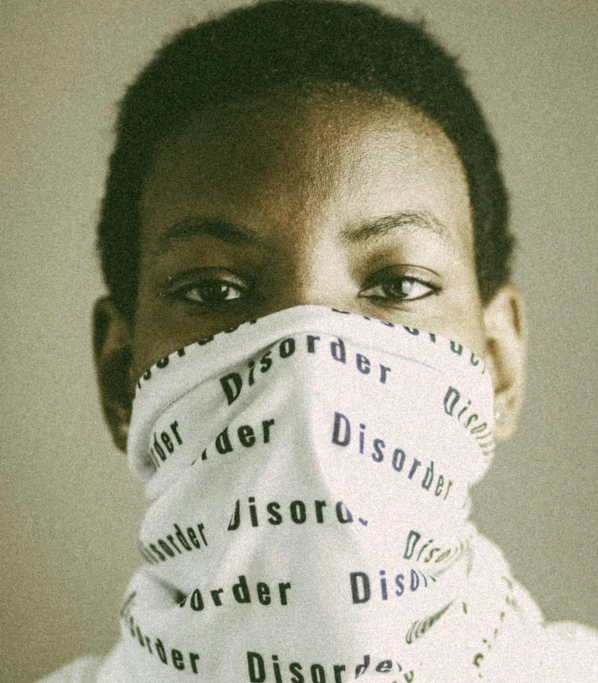 a close up of a person wearing a face mask, an album cover, by Lily Delissa Joseph, trending on pexels, disorder, genderless, (doctor), black teenage boy