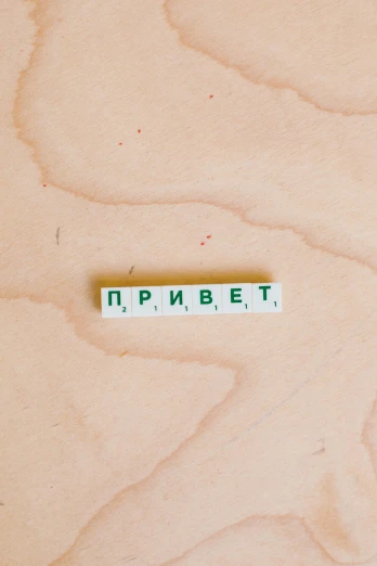 a piece of wood sitting on top of a table, an album cover, by andrei riabovitchev, trending on pexels, private press, green letters, broken tiles, russian academic, pride month