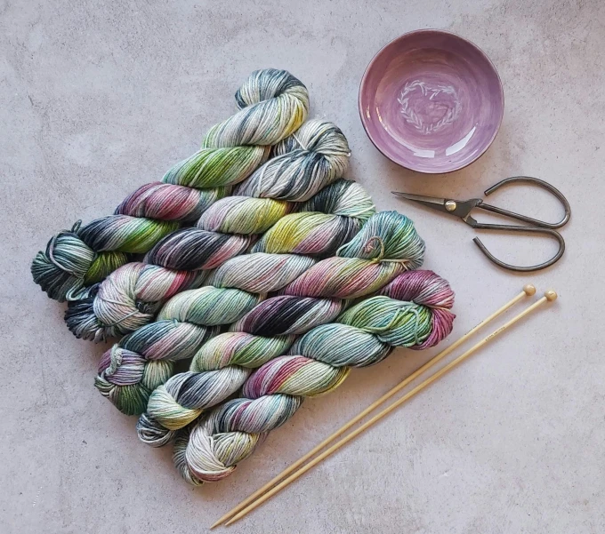 a bunch of yarn sitting on top of a table next to a pair of scissors, inspired by Perle Fine, green and pink colour palette, paint pour, thumbnail, multi - coloured