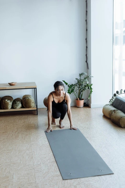 a woman standing on a yoga mat in a living room, unsplash, hurufiyya, crawling on the ground, full body photo, dwell, slate