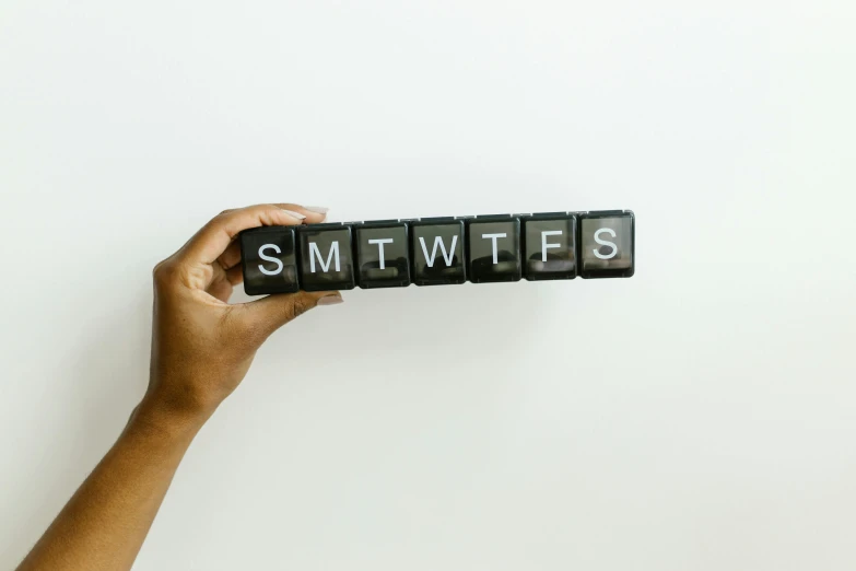 a person holding a sign that says sm tweees, by Sara Saftleven, pexels contest winner, calendar says monday, mechanical keyboard, 256x256, black