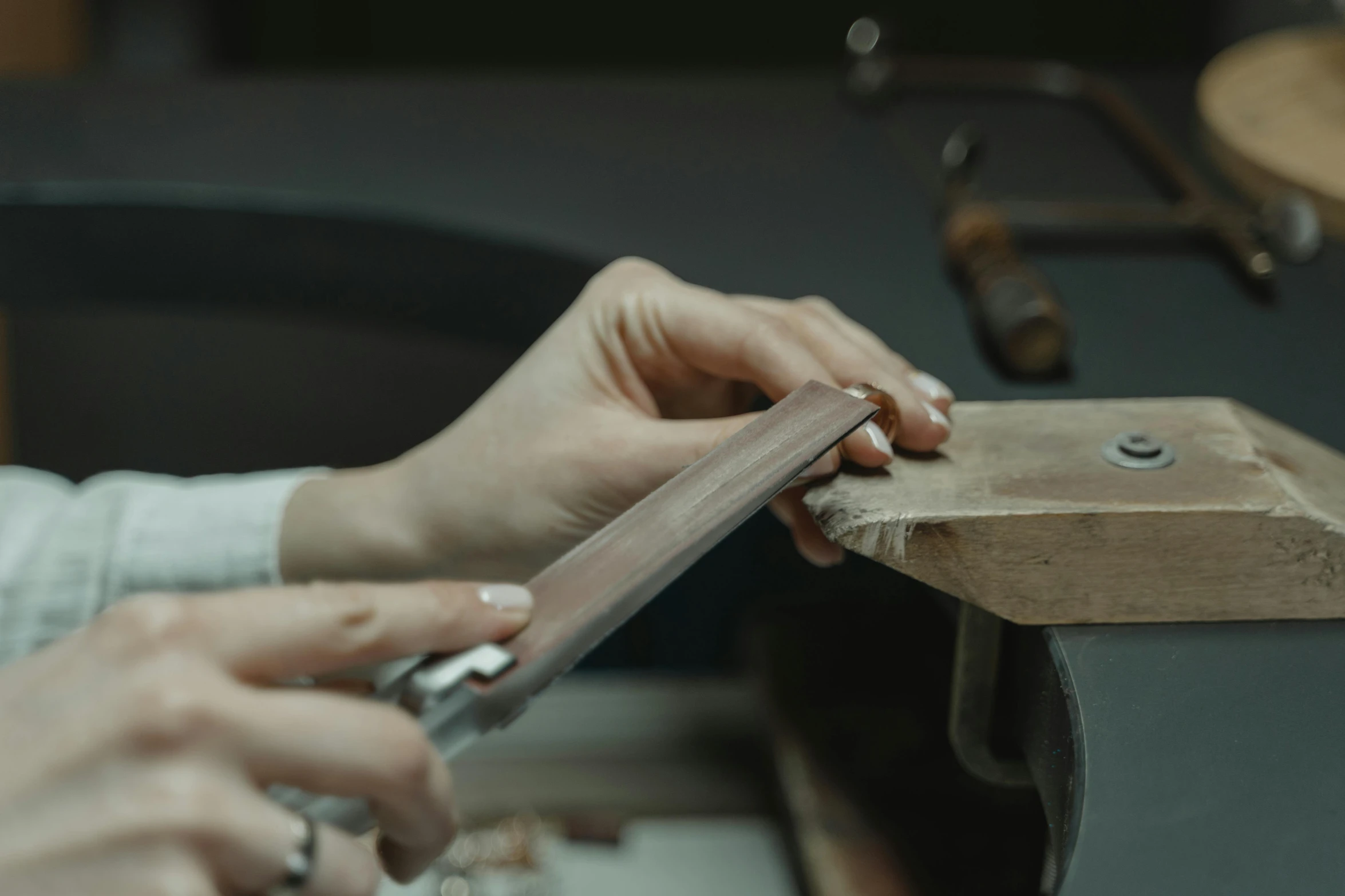 a close up of a person working on a piece of wood, by Emma Andijewska, pexels contest winner, arts and crafts movement, platinum jewellery, unsheathing her katana, thumbnail, small manufacture