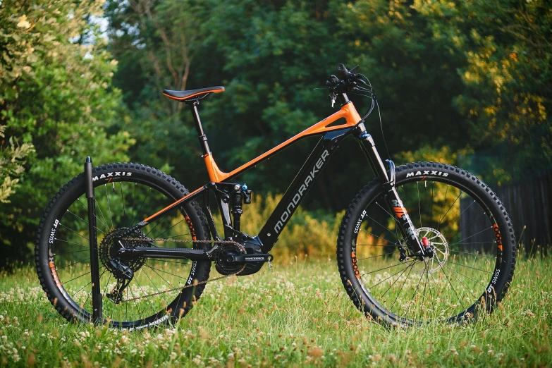 a bike sitting on top of a lush green field, orange and black, sauroform hybrid, high quality product image”, ultra sharpness