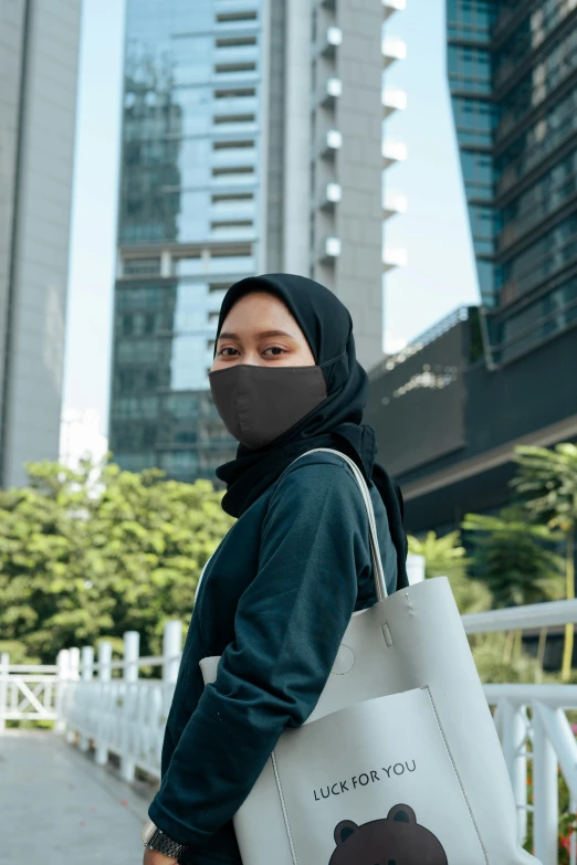 a woman wearing a face mask and carrying a tote bag, inspired by Cheng Jiasui, hurufiyya, wearing a black hoodie, kuala lumpur, charcoal color skin, in a cybercity