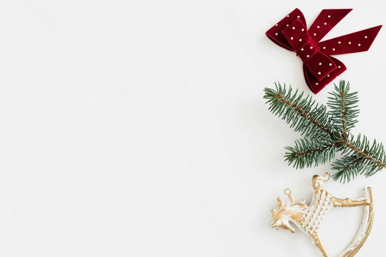 a close up of a christmas decoration on a white surface, by Emma Andijewska, pexels, minimalism, background image, golden ribbon, various items, square