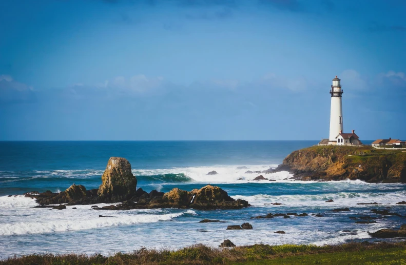 a lighthouse sitting on top of a cliff next to the ocean, bay area, background image, conde nast traveler photo