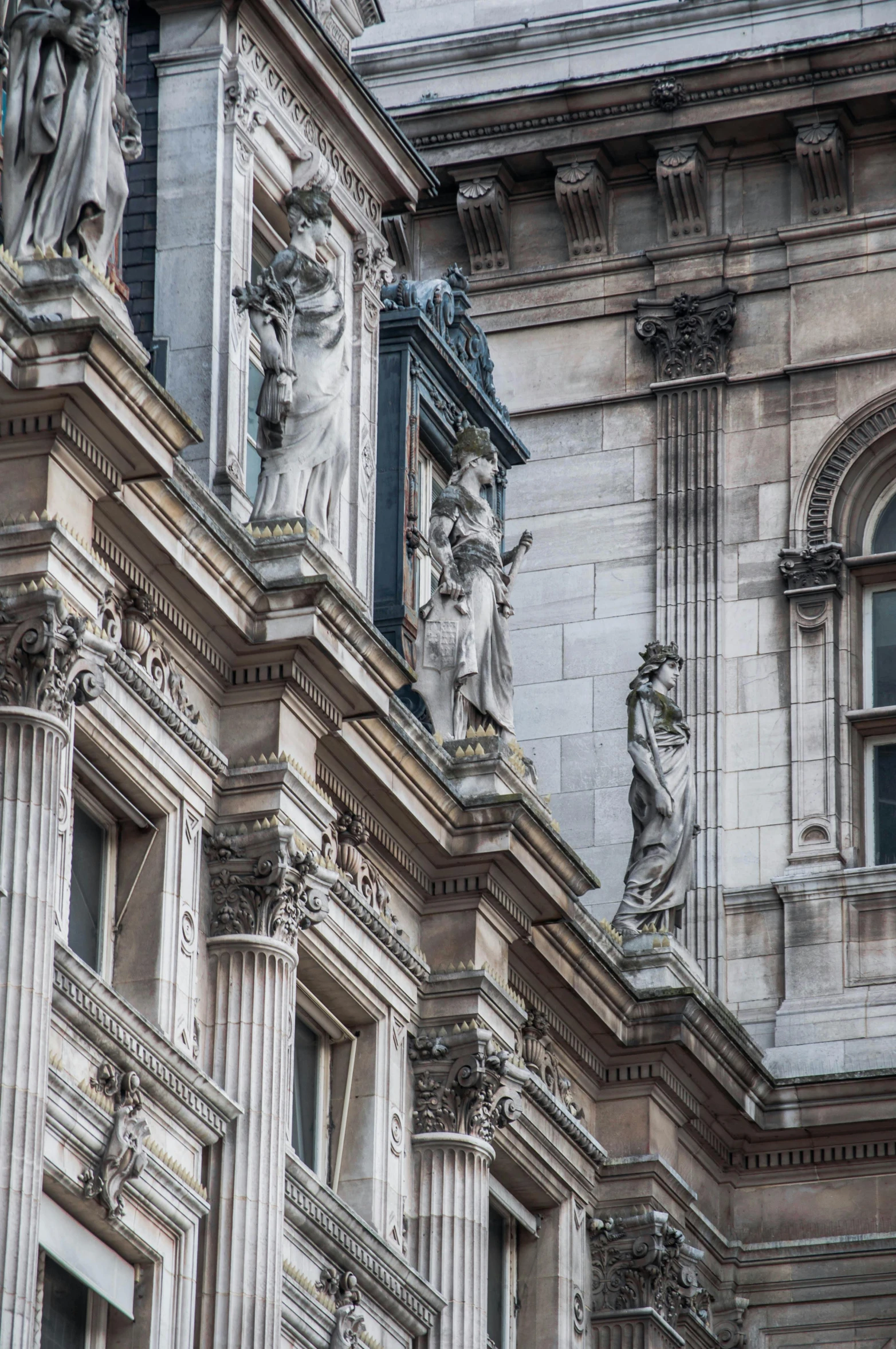 a clock that is on the side of a building, a statue, inspired by Sir Jacob Epstein, neoclassicism, buttresses, royal academy, buildings covered with greebles, elaborate hair worn up