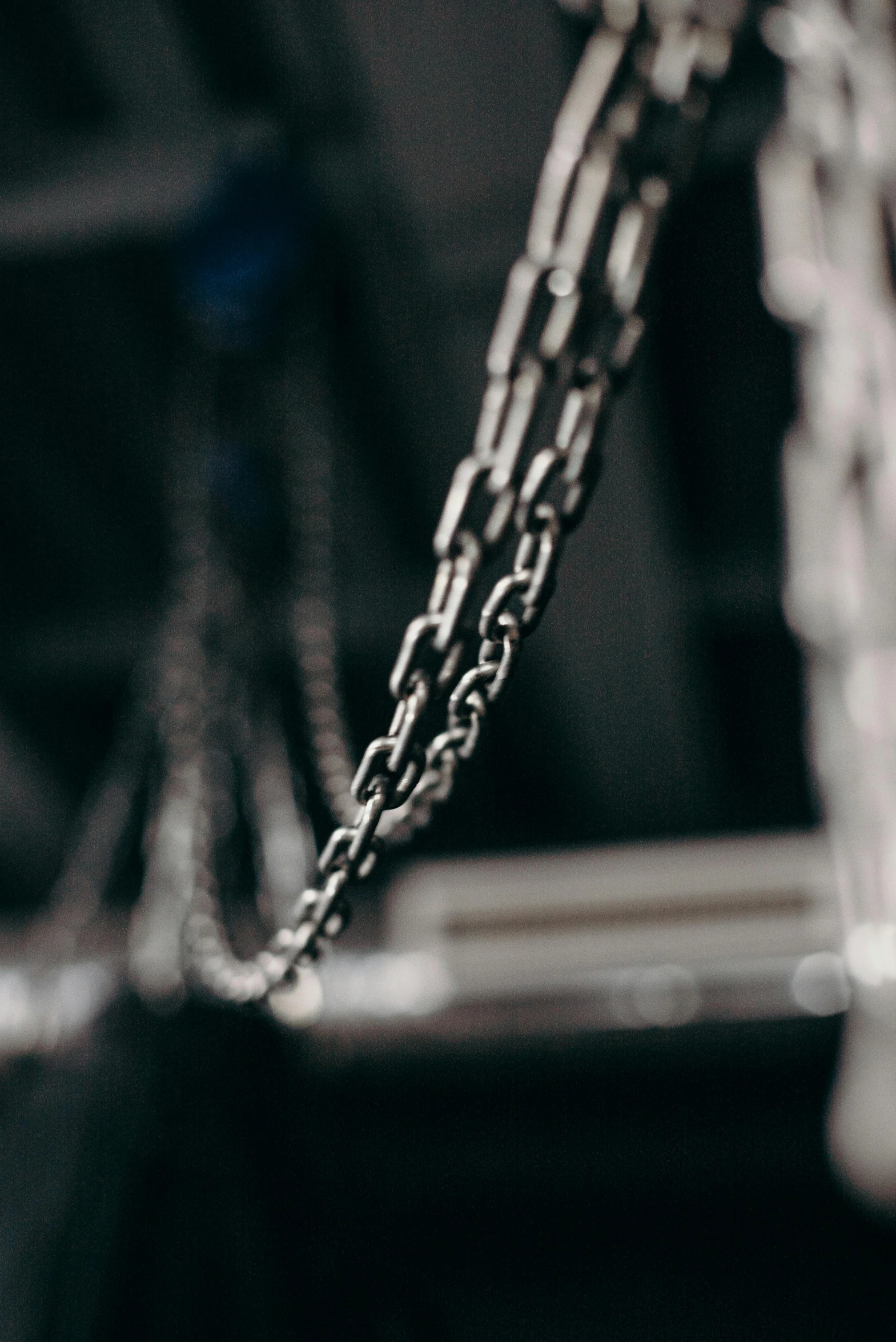 a close up of a chain hanging from a ceiling, by Adam Marczyński, unsplash, in an arena pit, profile image, made of metal, athletic crossfit build