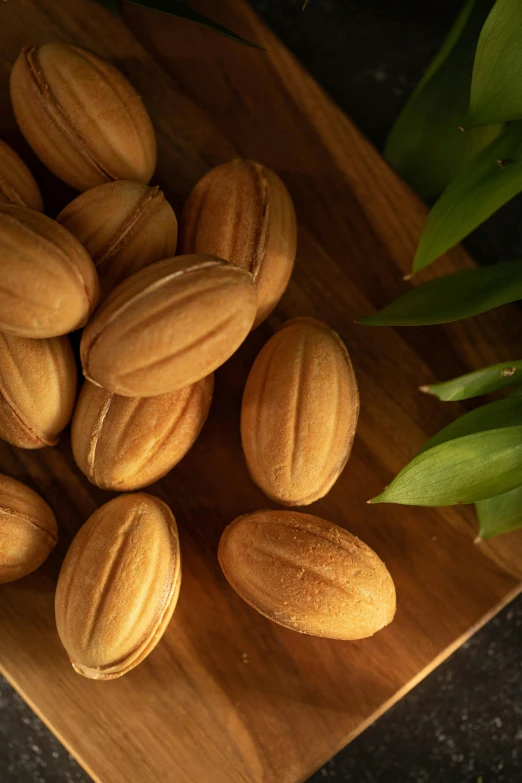 a bunch of almonds sitting on top of a wooden cutting board, inspired by Li Di, hurufiyya, in detail, a pair of ribbed, silk, various sizes