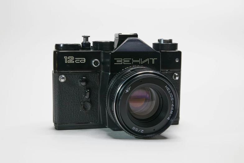 a black camera sitting on top of a white surface, 1962 soviet, detailed product image, filmic lut, front portrait
