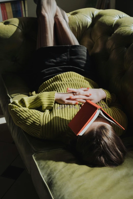 a person laying on a couch with a book, wearing a green sweater, upsidedown, 2019 trending photo, portrait photo