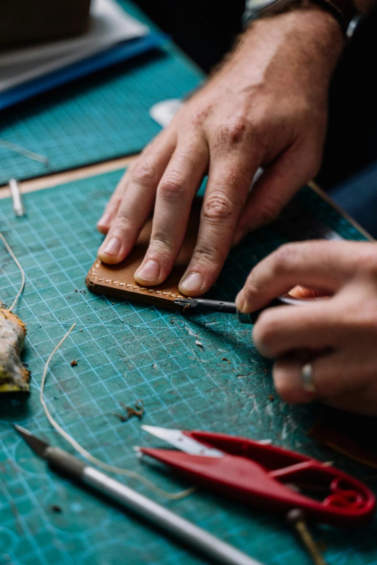 a close up of a person working on a piece of cloth, leather and suede, ornament, thumbnail, teaching